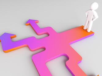 figure standing at multi-directional colourful arrows